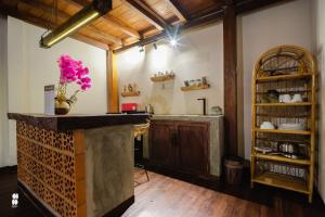 a kitchen with a counter with a vase of flowers at The Phalosaa Villa unit Family in Ngaglik