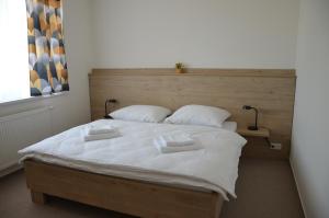 a bedroom with a large bed with two towels on it at Penzión Rocket Club in Lučenec