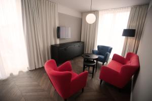 a living room filled with furniture and a tv at Hotel Caroline in Vienna