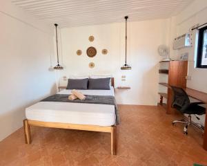 a bedroom with a bed and a desk at New Studio with Balcony , General Luna in General Luna