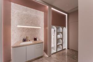 a bathroom with a sink and a mirror at Mercure Qingdao Coast in Qingdao +49 photos
