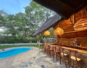 a bar with chairs next to a swimming pool at Pioneer Camp in Lusaka