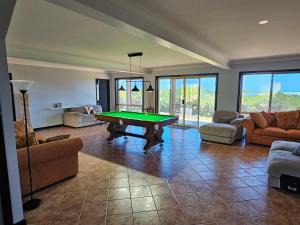 a living room with a pool table on a tile floor at Magic at the Mouth in Nelson