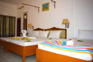 Rúm í herbergi á Palm Beach Resort by Yosha Guest