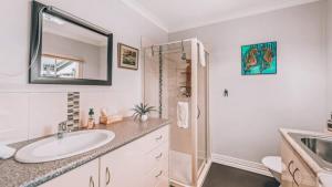 a white bathroom with a sink and a shower at Family Cottage in Bendigo