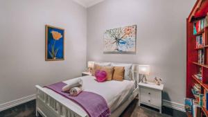 a bedroom with a bed with two dolls on it at Family Cottage in Bendigo +14 photos