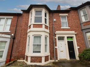a red brick house with a white door at Grosvenor 126 Trendy Jesmond Whole Apartment in Jesmond