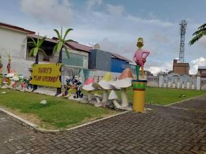 a group ofulptures of benches on the side of a street at Villa Bukit Asri Berastagi in Berastagi