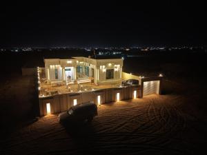 a house lit up at night with lights on it at شاليه العهد Al Ahad in Badīyah