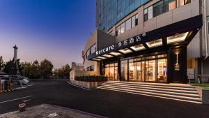 a building with a sign on the front of it at Mercure Qingdao Coast in Qingdao