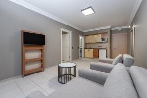 a living room with a couch and a tv at Villa Sunflower Hotel - All Inclusive in Alanya