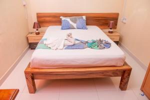 a bed with two dolls laying on top of it at Chez Jenny port Mathurin in Rodrigues Island +3 photos