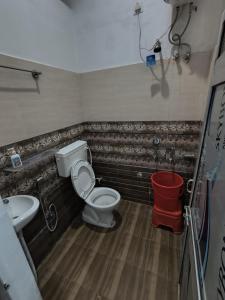 a bathroom with a toilet and a sink at Jai Krishna Guest House in Ayodhya +6 photos