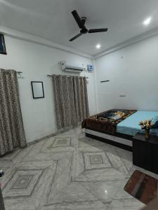 a bedroom with a bed and a ceiling fan at Jai Krishna Guest House in Ayodhya