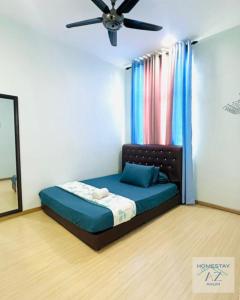a bedroom with a bed with a ceiling fan at Homestay AZ Kulim in Kulim
