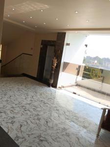 a room with a lobby with a large window and a staircase at VR Palace in Kānpur