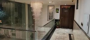 a hallway with a glass railing and a door at VR Palace in Kānpur