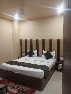 a bedroom with a large bed with black and white pillows at VR Palace in Kānpur