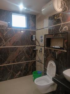 a bathroom with a toilet and a sink and a window at VR Palace in Kānpur +10 photos