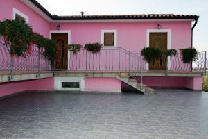 a pink house with stairs and plants on it at Tourist Farm Robivera in Šmarje