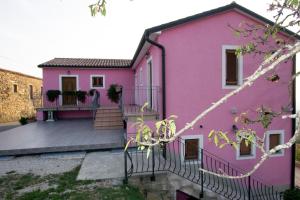 a pink house with a balcony at Tourist Farm Robivera in Šmarje +11 photos