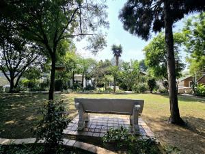 a park bench sitting in a park with trees at Waterfall City Guest Lodge in Sandton