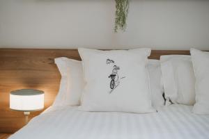a bed with white pillows with a drawing of a man riding a bike at Mountain Whisper Chalet in Braşov