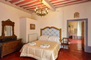 - une chambre avec un lit, un miroir et un lustre dans l'établissement Palazzo Tombesi Trecci, à Montepulciano