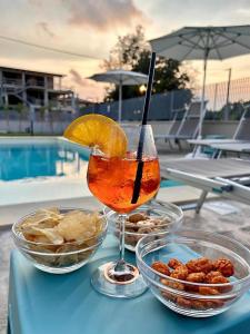 a drink on a table next to bowls of food at Essenza Mediterranea Tropea in Tropea