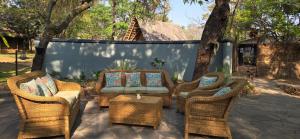 a group of wicker chairs and a couch on a patio at Pioneer Camp in Lusaka