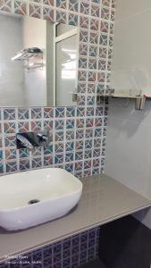 a bathroom with a white sink and a mirror at Shree Krushn in Bhuj +4 photos