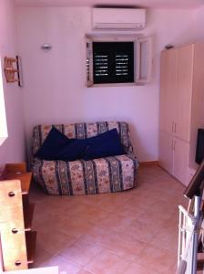 ein Wohnzimmer mit einer Couch in der Ecke in der Unterkunft Casa Carla in Cavo