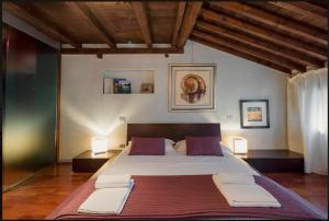 a large bed in a room with two lamps at Porta Vittoria Apartment in Verona