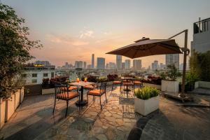 a patio with a table and chairs and an umbrella at GrandView Hotel & Residence Hanoi in Hanoi