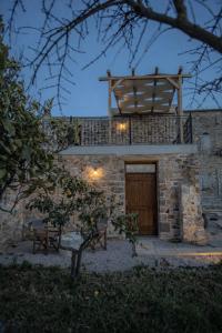 a building with a wooden door and a balcony at Stone Olympi Lodges - Chios Cozy Hideaways in Olýmpoi