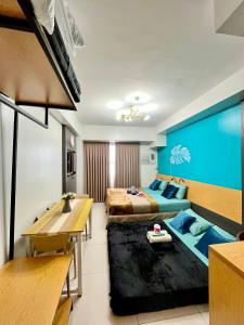 a hotel room with two beds and a dining table at Horizons 101-Premium Studio 42J in Cebu City