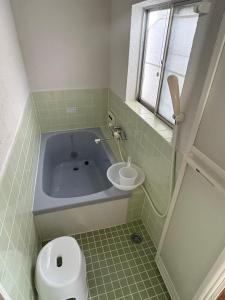 a bathroom with a tub and a toilet and a sink at 日牟禮乃宿 日牟禮八幡宮徒歩4分ラコリーナ車4分 in Omihachiman