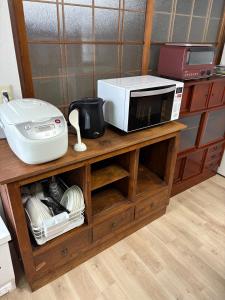a microwave sitting on top of a wooden cabinet at 日牟禮乃宿 日牟禮八幡宮徒歩4分ラコリーナ車4分 in Omihachiman