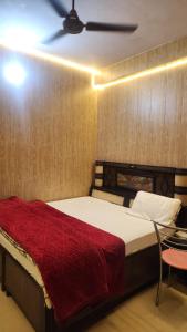 a bedroom with a bed and a ceiling fan at Krishna guest house in Mussoorie