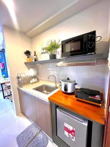 a small kitchen with a sink and a microwave at Horizons 101-Premium Studio 42J in Cebu City