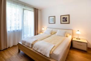 a bedroom with a large bed and a large window at Appartements Kanauf in Krumpendorf am Wörthersee
