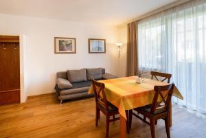 a living room with a table and a couch at Appartements Kanauf in Krumpendorf am Wörthersee