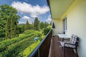 a balcony with a table and two chairs and a view at Appartements Kanauf in Krumpendorf am Wörthersee +11 photos