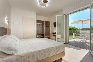 a bedroom with a bed and a balcony with an umbrella at I Delfini - Natural B&B in Cesenatico +57 photos