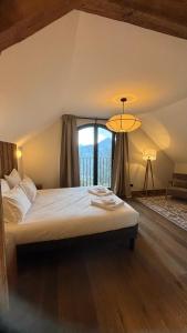 a bedroom with a large bed with a large window at L'Orée du Peney in Saint-Jean-dʼArvey