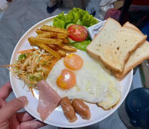 a plate of food with eggs and toast and french fries at Luang Prabang Golden Lotus Villa River View in Luang Prabang