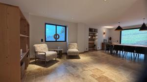 a living room with a dining room table and chairs at L'Orée du Peney in Saint-Jean-dʼArvey