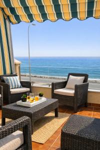 a patio with chairs and tables and a view of the ocean at Brisa Chilches nº 5 in Málaga