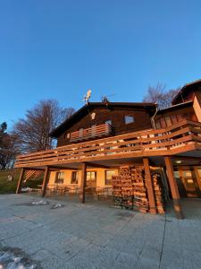 a large building with a pile of logs at Planinski dom Kal in Dol pri Hrastniku