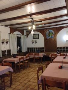 a restaurant with tables and chairs in a room at Planinski dom Kal in Dol pri Hrastniku